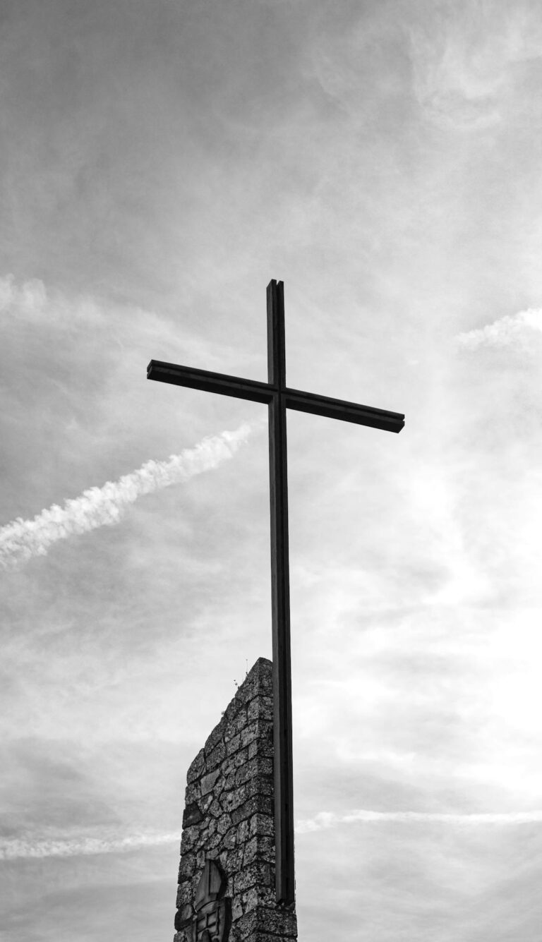 A dramatic black and white shot of a cross at Monestir de Montserrat, Spain, depicting spirituality.